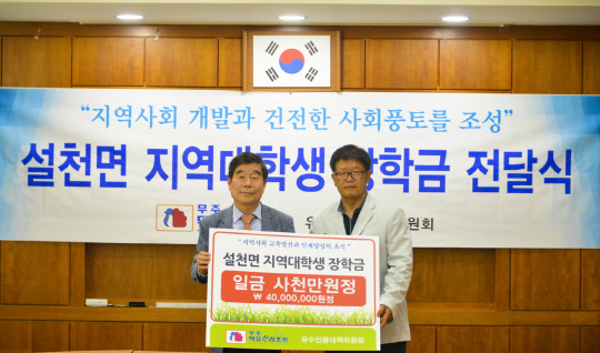 부영그룹 무주덕유산리조트 김시권 대표이사(왼쪽)가 5월 31일 오후 유수인용대책위원회 백남운 위원장에게 저소득가구 대학생 장학금을 전달하는 모습. <부영그룹 제공>